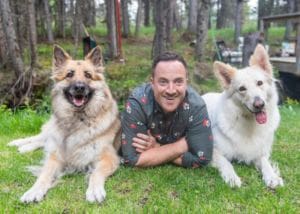 Clarke Foster, a philanthropy and technology professional who was laid off from Benevity last week, posing with two dogs.