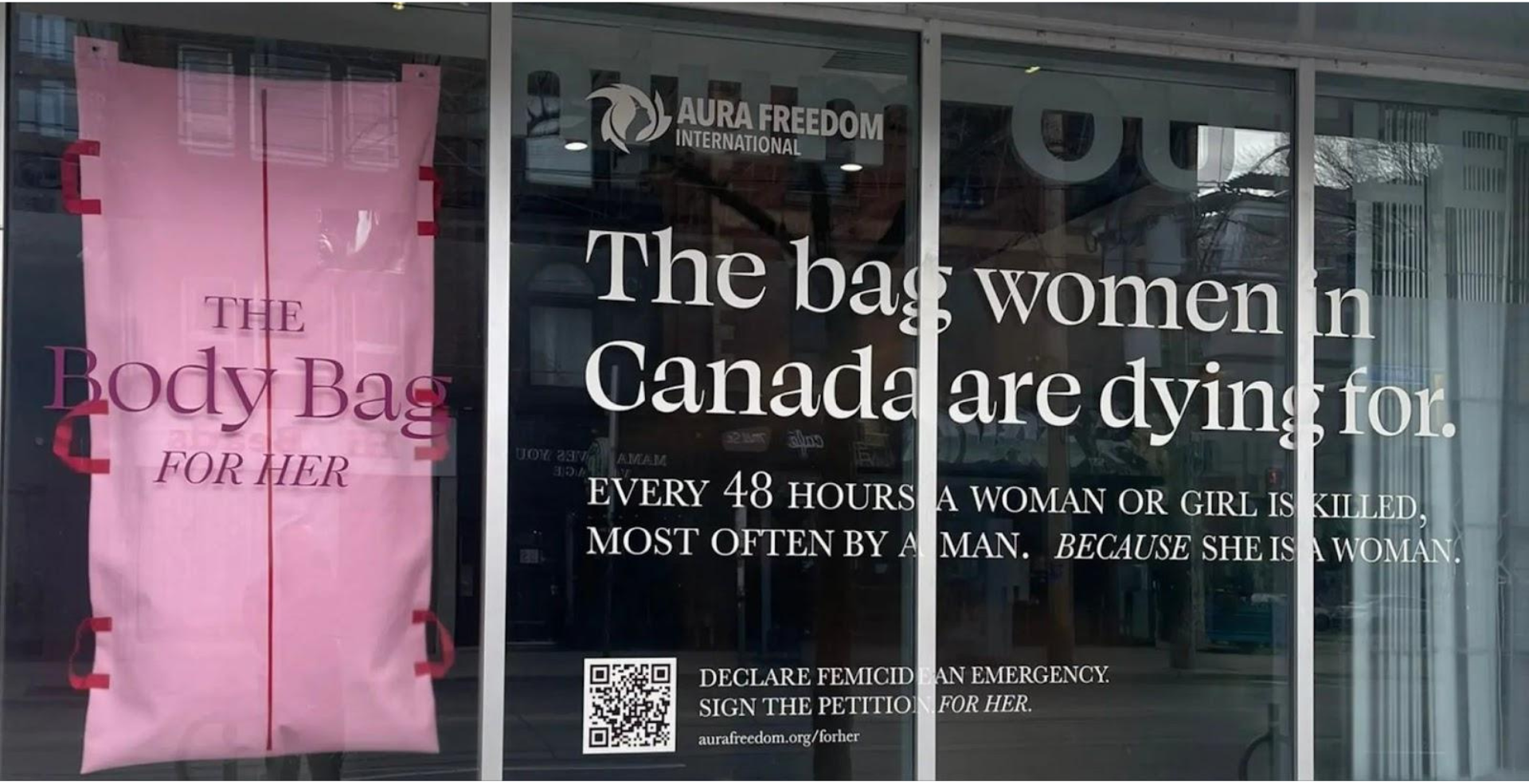 A pink body bag hangs in the window of Toronto gallery It’s OK* Studios on Nov. 24, 2023, as part of a controversial campaign by Canadian charity Aura Freedom International to raise awareness about femicide.