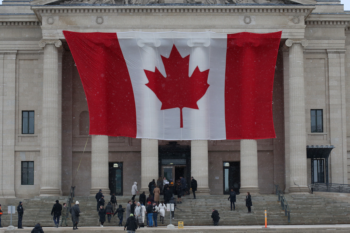 A giant Canadian flag hangs from the Manitoba Legislative Building in Winnipeg.