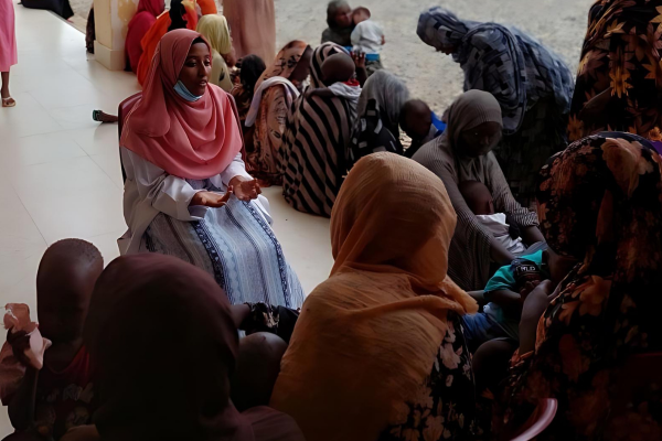 A woman educates others at an emergency response room in Sudan, funded by a group cash transfer. (CORE/Supplied photo.)