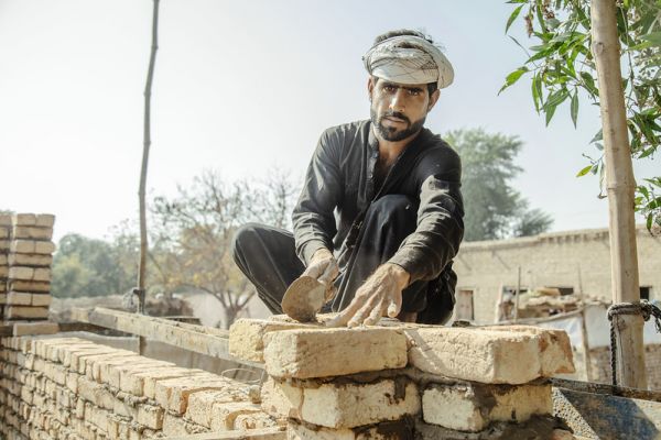 A man rebuilds his home following the August 2022 floods in Pakistan. Photo: Shuja Hakim/United Nations Development Program
