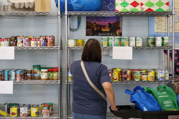 Clients collect food items at a bi-weekly foodbank hosted by Harvest Manitoba, which distrubutes food to more than 380 community organizations, in Winnipeg on May 29, 2025. Photo: Shannon VanRaes