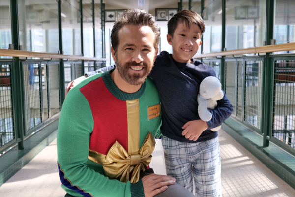 Canadian actor Ryan Reynolds poses with Everett Ho in the 2023 SickKids campaign video. Everett cheekily tells Reynolds during the video that he “looks so stupid in that sweater.” (Ryan Reynolds/YouTube)