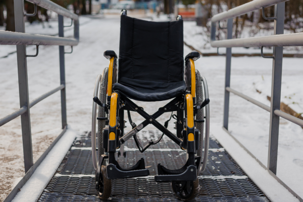 Oh, look at this lovely ramp and this lovely wheelchair leading straight to what appears to be a gravel lot covered in snow with zero sidewalks. (Canva)