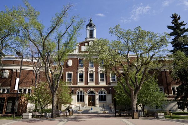 A four storey redbrick administrative building of late Victorian style on a sunny spring day.