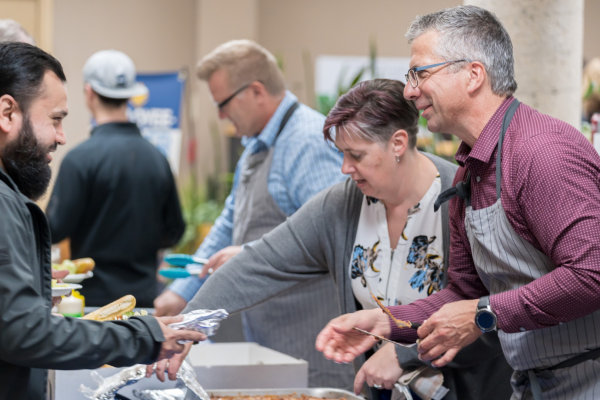 Chad Friesen, right, of Friesens Corporation, serves up a Thanksgiving lunch during the company’s Employee Owner Days in October of 2023.